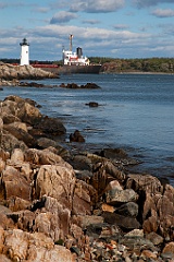 Portsmouth Lighthouse Guides Ship From Rocky Shore